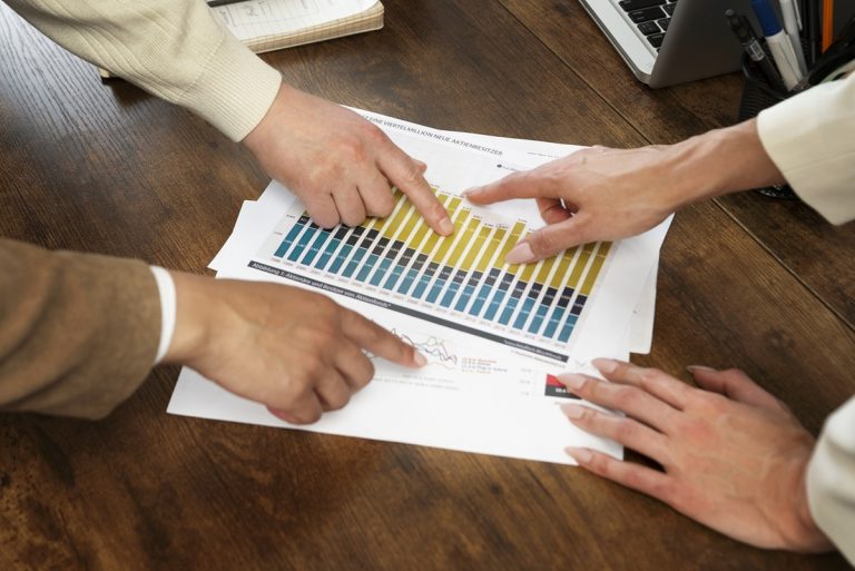 People pointing to sales charts